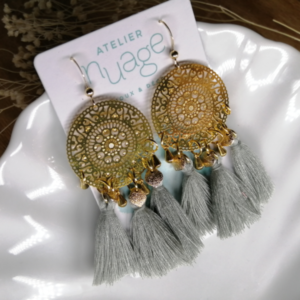 boucles d'oreilles avec estampe dorée et pompons gris-vert. 3 sur chaque boucle.
