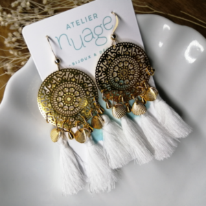 boucles d'oreilles avec estampe dorée et pompons blancs. 3 sur chaque boucle.